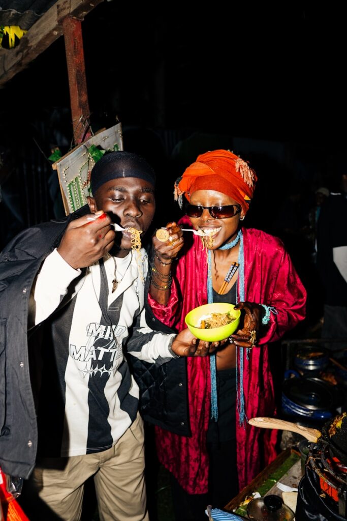 Two people enjoy a meal at a food stall.