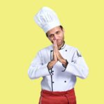 a person wearing a chef's hat and holding the chin
